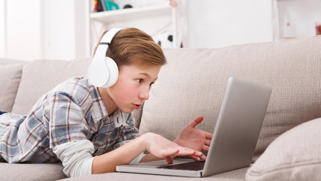 Ребенок в наушниках за компьютером