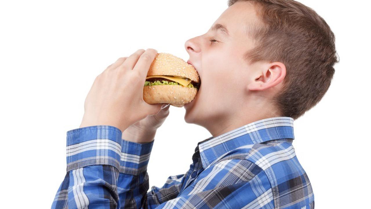 Голодные подростки. Мальчик ест бургер. Мальчик ест гамбургер. Мальчик с гамбургером. Мальчик ест фаст фуд.